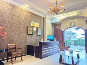 a lobby with a desk and a chair and a chandelier at Pavotel Style Naz Hotel in Kamparganya