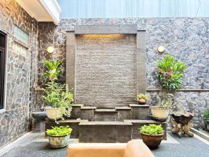 a stone wall with a bench and potted plants at Pavotel Style Naz Hotel in Kamparganya