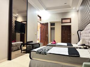 a bedroom with two beds and a flat screen tv at Pavotel Style Naz Hotel in Kamparganya