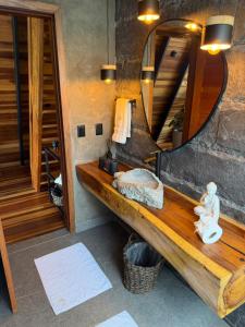 a bathroom with a wooden bench and a mirror at Zamaya Bangalôs in Sao Jorge