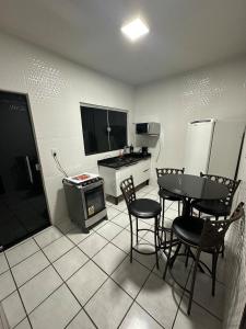 a kitchen with a table and chairs and a kitchen with a refrigerator at Casa no Centro in Corumbá +10 photos