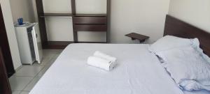 a white bed with two rolled towels on it at Da Silva residência à 200 metros da praia do Bessa in João Pessoa