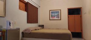 a small bedroom with a bed and a door at Magical Garden in Savaneta