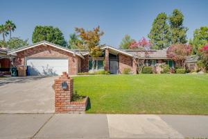 a brick house with a garage at Your Poolside Hideaway in Bakersfield