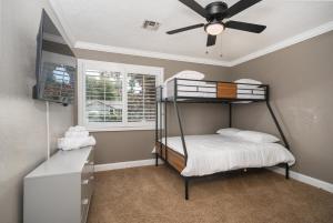 a bedroom with a bunk bed and a ceiling fan at Your Poolside Hideaway in Bakersfield