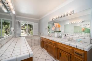 a bathroom with two sinks and a large mirror at Your Poolside Hideaway in Bakersfield +11 photos