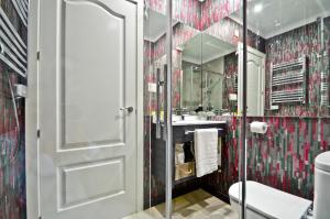 ein Badezimmer mit Dusche, Toilette und Waschbecken in der Unterkunft The Zentral Arenal Suites in Sevilla