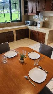 a wooden table with plates and utensils on it at Cypress Resort Cipanas in Barukupa +5 photos