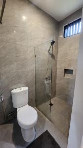 a bathroom with a toilet and a shower at Cypress Resort Cipanas in Barukupa
