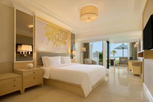 a bedroom with a large white bed and a balcony at Dusit Thani Laguna Phuket in Bang Tao Beach