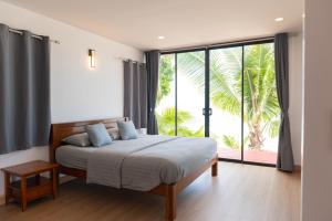 a bedroom with a bed and a large window at IBIZA BEACH Resort in Haad Yao