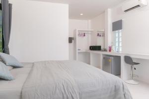 a white bedroom with a bed and a desk at IBIZA BEACH Resort in Haad Yao