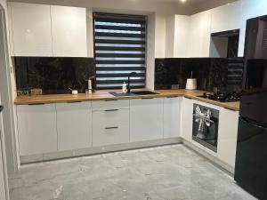 a kitchen with white cabinets and a counter top at Apartament Ostrowiec Świętokrzyski Browarna 4 in Ostrowiec Świętokrzyski