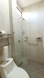 a bathroom with a toilet and a glass shower at Punta Colibrí in Brisas de Zicatela