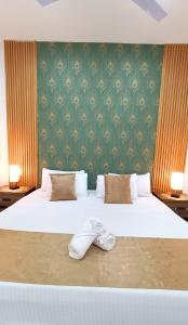 a bedroom with a large white bed and a green wall at Punta Colibrí in Brisas de Zicatela