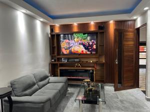 a living room with a couch and a flat screen tv at Casa Pacifico Azul in Ixtapa