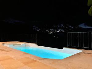 a swimming pool at night on a patio at Villa Majo in Nocaima