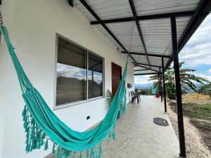 a hammock hanging from the side of a house at Villa Majo in Nocaima