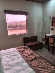 a bedroom with a bed and a window and a desk at Lords Hotel in Agra