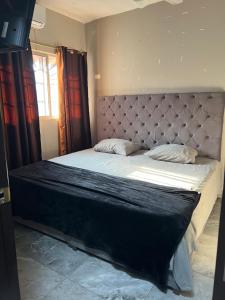 a bedroom with a large bed with a padded headboard at Casa Pacifico Azul in Ixtapa