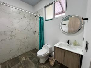 a bathroom with a toilet and a sink and a mirror at Villa Majo in Nocaima +7 photos