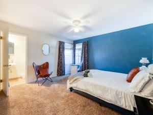 a blue bedroom with a bed and a chair at The Nest with Firepit & Backyard Oasis in Klamath Falls