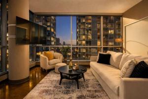 a living room with a white couch and a large window at Summit Mountain & Skyline Views Beltline in Calgary