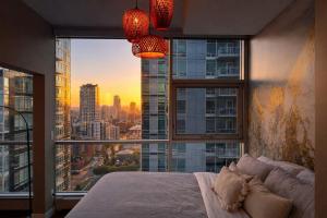 a bedroom with a large window with a view of a city at Summit Mountain & Skyline Views Beltline in Calgary +24 photos