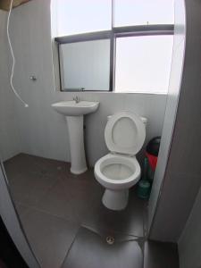 a bathroom with a white toilet and a sink at Chepe de mi Corazon in Abancay +3 photos