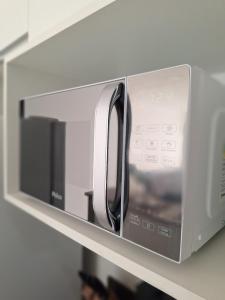 a microwave oven on a shelf in a kitchen at Blue Hope, 467, LUXO em Vitória ES in Vitória