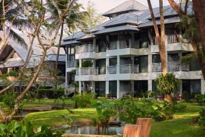an apartment building with a garden in front of it at Dusit Thani Laguna Phuket in Bang Tao Beach