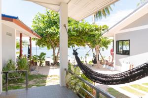 a hammock on the porch of a house overlooking the ocean at IBIZA BEACH Resort in Haad Yao