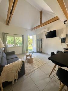 a living room with a blue couch and a piano at Carrière de la Tour in Condé-sur-Sarthe
