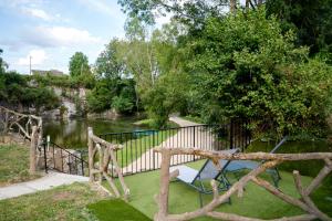 a garden with a bench next to a river at Carrière de la Tour in Condé-sur-Sarthe