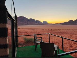 a view of the desert from a room with a table and chairs at Starlit Wadi Rum camp in Wadi Rum