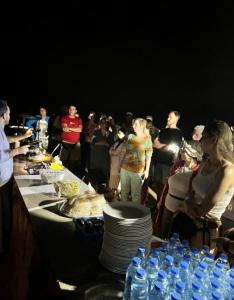 a group of people standing around a table with water bottles at Starlit Wadi Rum camp in Wadi Rum