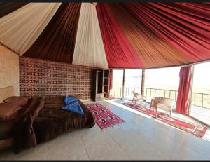 a bedroom with a large bed and a balcony at Starlit Wadi Rum camp in Wadi Rum