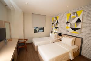 a hotel room with two beds and a tv at Nite & Day Laguna Bintan in Tanjung Pinang
