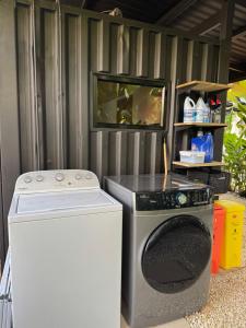 a washing machine sitting next to a tv at Ruca Lodge - Luxury Container Tiny Home Surrounded by Nature in Uvita