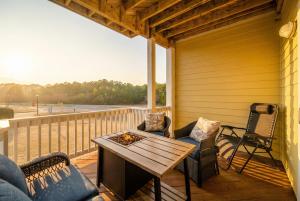 a patio with a table and chairs on a deck at The Wright Stuff OBX in Kill Devil Hills