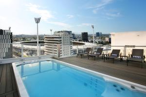 a rooftop deck with a swimming pool on a building at Swiss-Belhotel Woolloongabba, Brisbane in Brisbane