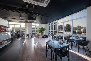 a restaurant with tables and chairs and large windows at Swiss-Belhotel Woolloongabba, Brisbane in Brisbane