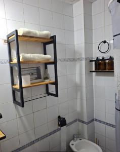 a bathroom with a toilet and a shelf on the wall at Alojamiento Victoria in Corrientes +4 photos