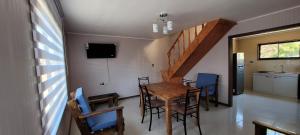 a dining room with a wooden table and chairs at Cabañas San Pedro in Arauco