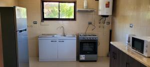 a kitchen with a sink and a stove and a window at Cabañas San Pedro in Arauco +12 photos