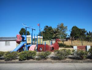a playground in a park with a slide at Cabañas San Pedro in Arauco