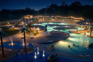 a large swimming pool at night with people in it at The Wright Stuff OBX in Kill Devil Hills