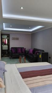 a living room with a bed and a couch at Hostal Imperio la Kennedy in Quito