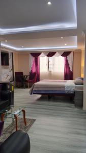 a hotel room with a bed and a couch at Hostal Imperio la Kennedy in Quito