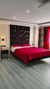 a bedroom with a large bed with a red blanket at Hostal Imperio la Kennedy in Quito +6 photos